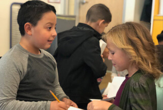 2 students interacting in classroom setting