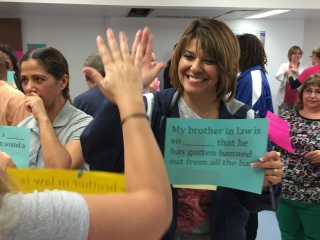 Woman holding up a sign, saying hello to another person